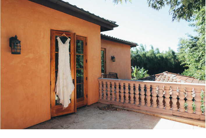 Brides laces shift dress handing on Tuscan private estate balcony