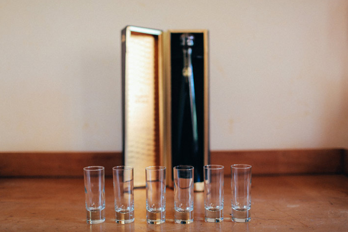 shot glasses lined up with bottle of scotch in wooden box