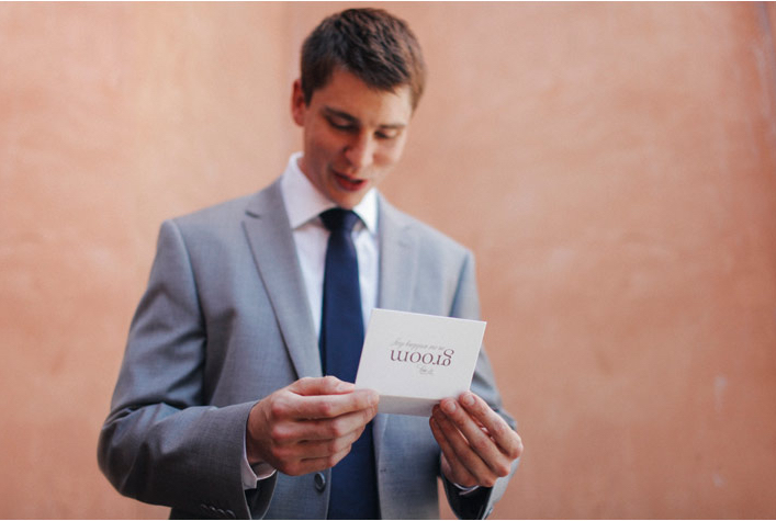 Portrait of Groom reading wedding card greeting card from bride