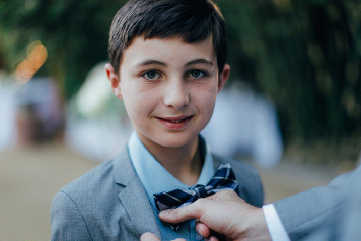 close-up of ring bearer wearing plaid bow-tie