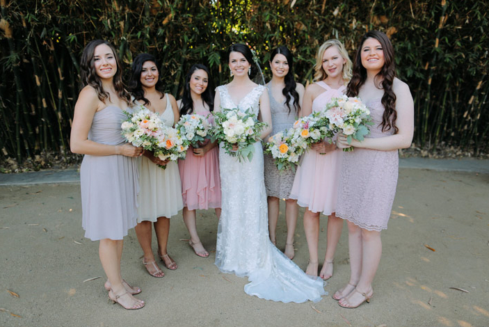 bridal party in shades of blush and taupe with bride in lace dress