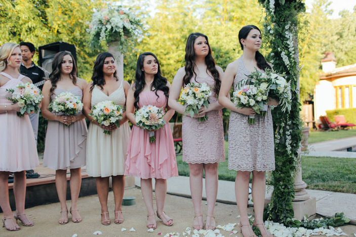 bridal party standing at alter in shades of blush and taupe