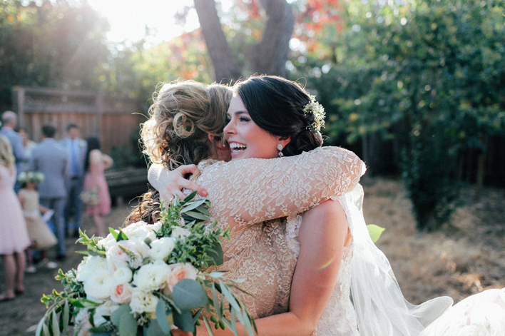 bride hugs mother of groom in golden light