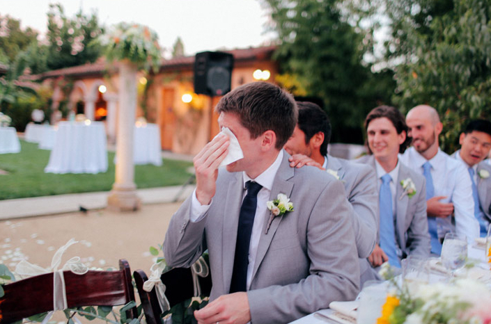 groom dabbing eyes during toasts